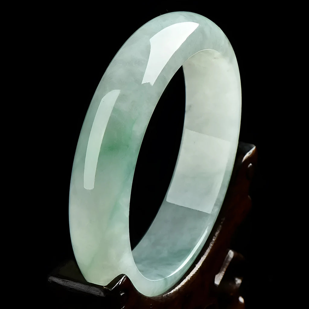 A light green jade bracelet for men and women, shown on a wrist, with a natural stone texture.