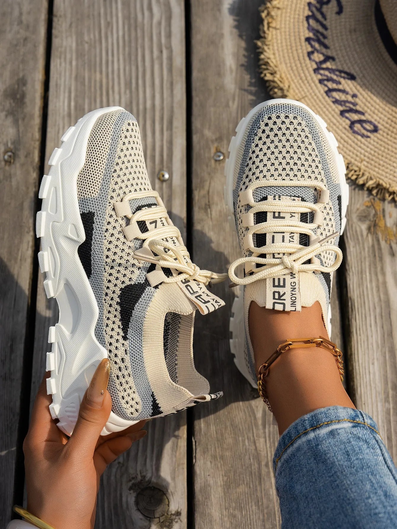 Women's Flyknit mesh sneakers in grey and white colour with flat rubber sole and lace-up front.