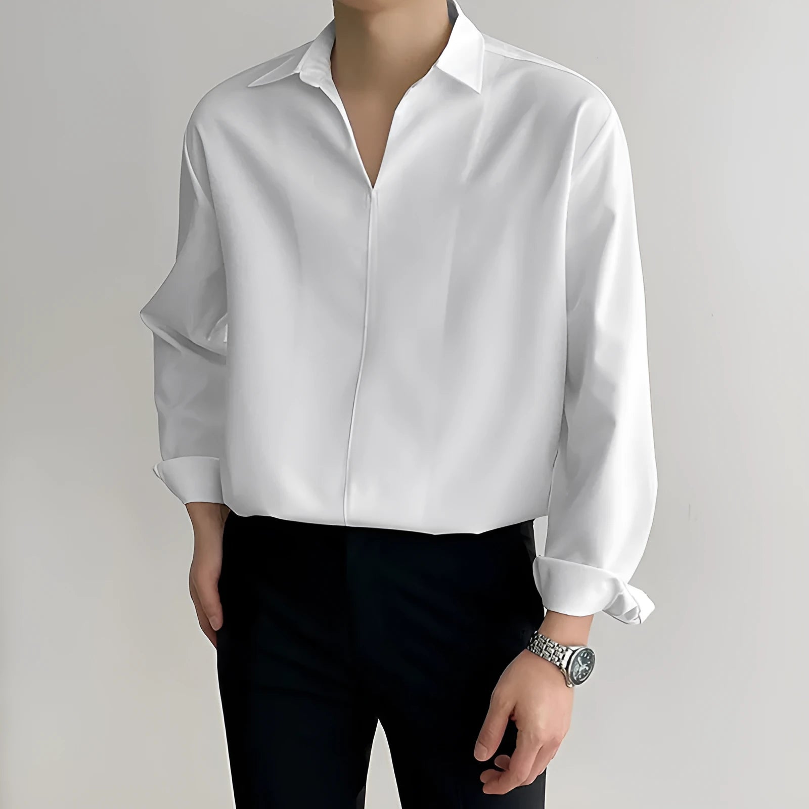 Man wearing a loose fit light business casual shirt in blue, showing lapels and long sleeves.