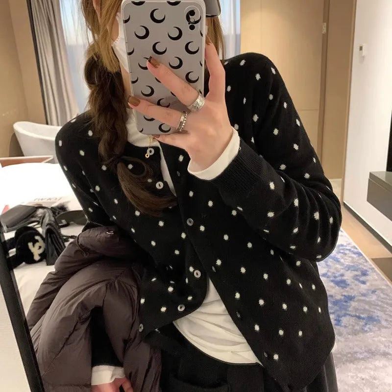 Grey dot knitted women's cardigan with crocheted flower details on the front.