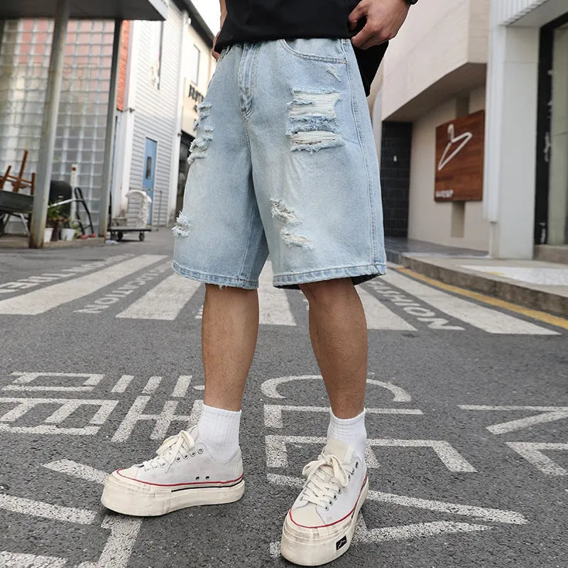 Light blue ripped denim shorts with distressed detailing and loose straight cut fit