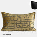 Gold geometric pattern on a velvet square cushion and a rectangular waist pillow against a sofa.