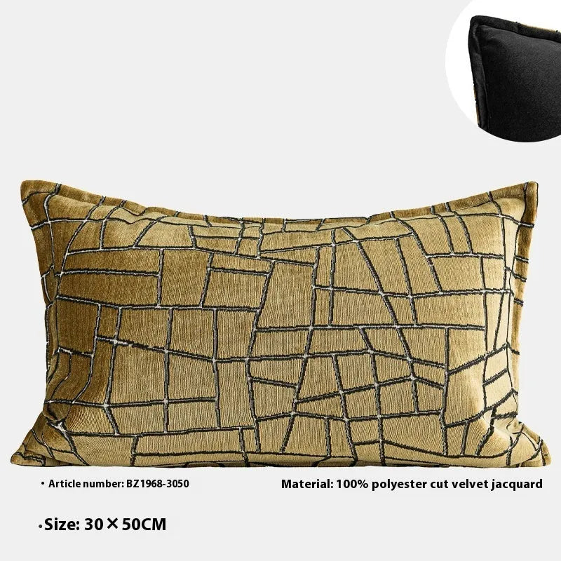 Gold geometric pattern on a velvet square cushion and a rectangular waist pillow against a sofa.