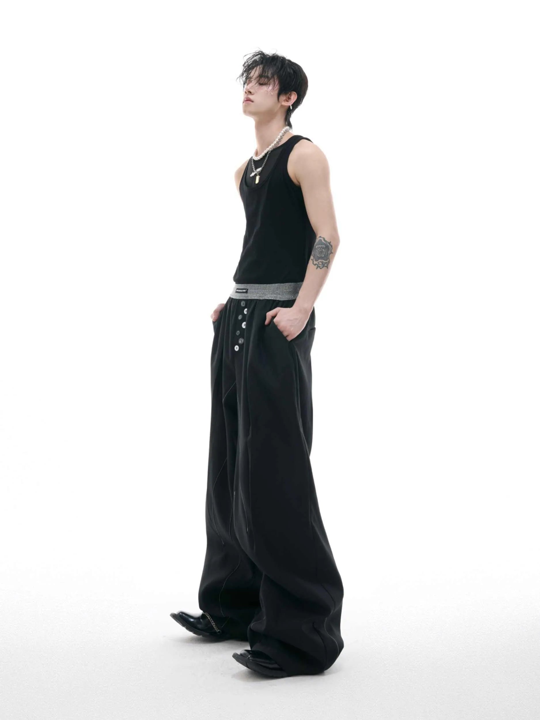 Black straight-leg high-waist trousers with button detail on smart casual model