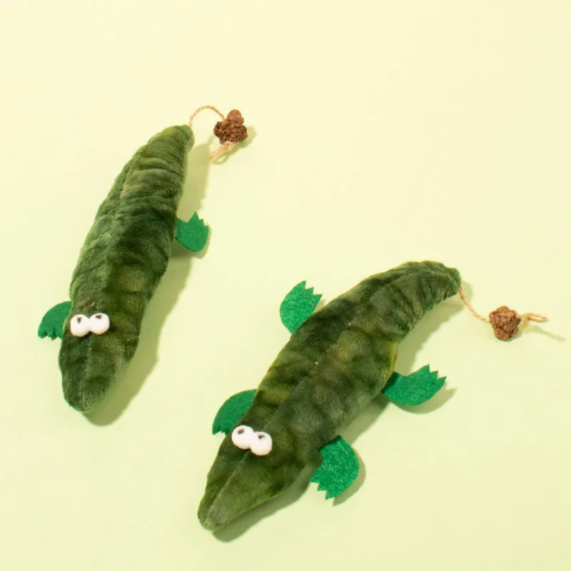 Green plush alligator catnip toy made from cotton fabric on a plain background.
