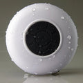 Portable Bluetooth speaker with suction cup showing front speaker grille and side buttons