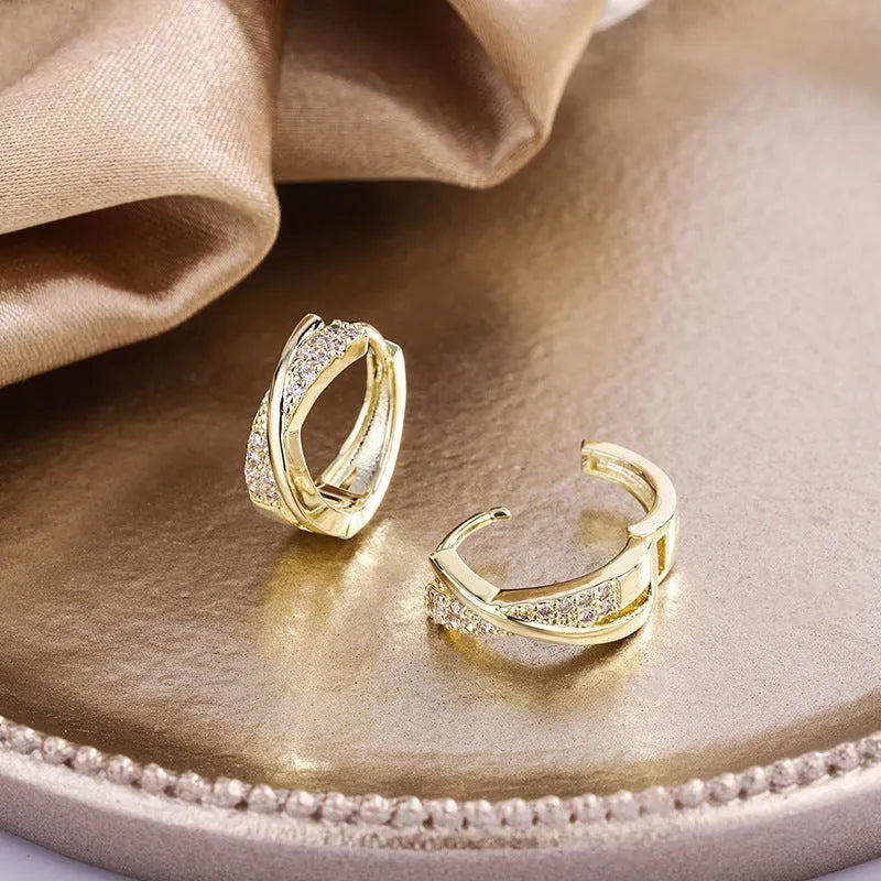 A pair of geometric drop earrings in 14K yellow, made from copper with zircon accents.