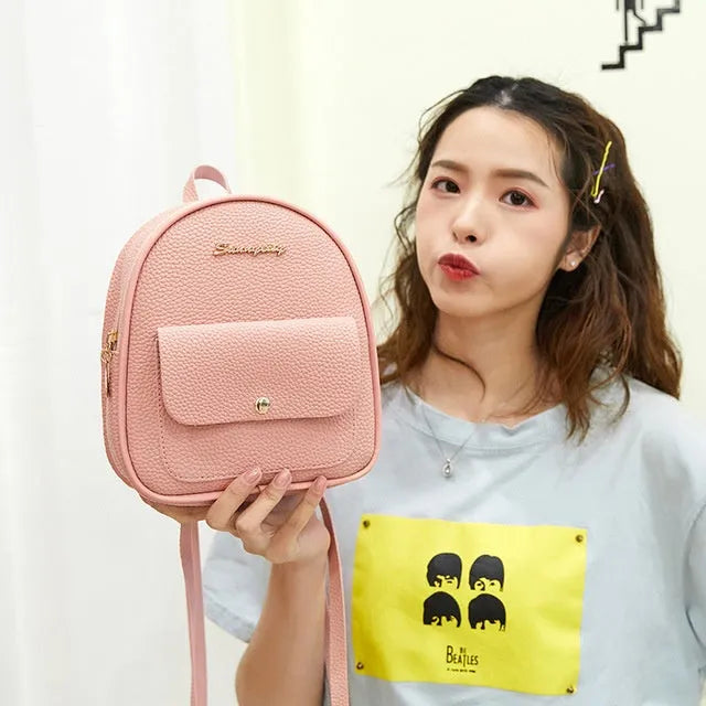 Compact black PU leather women's shoulder bag with zipper, shown next to a mobile phone for scale.