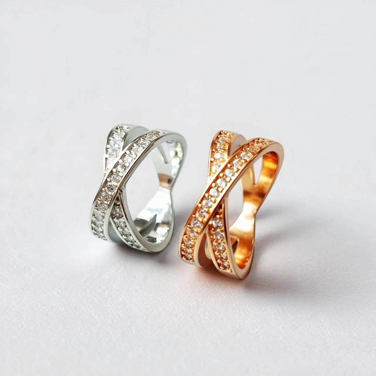 Simple geometric copper cross ring with micro-inlaid zircon stones in silver or rose gold finish.