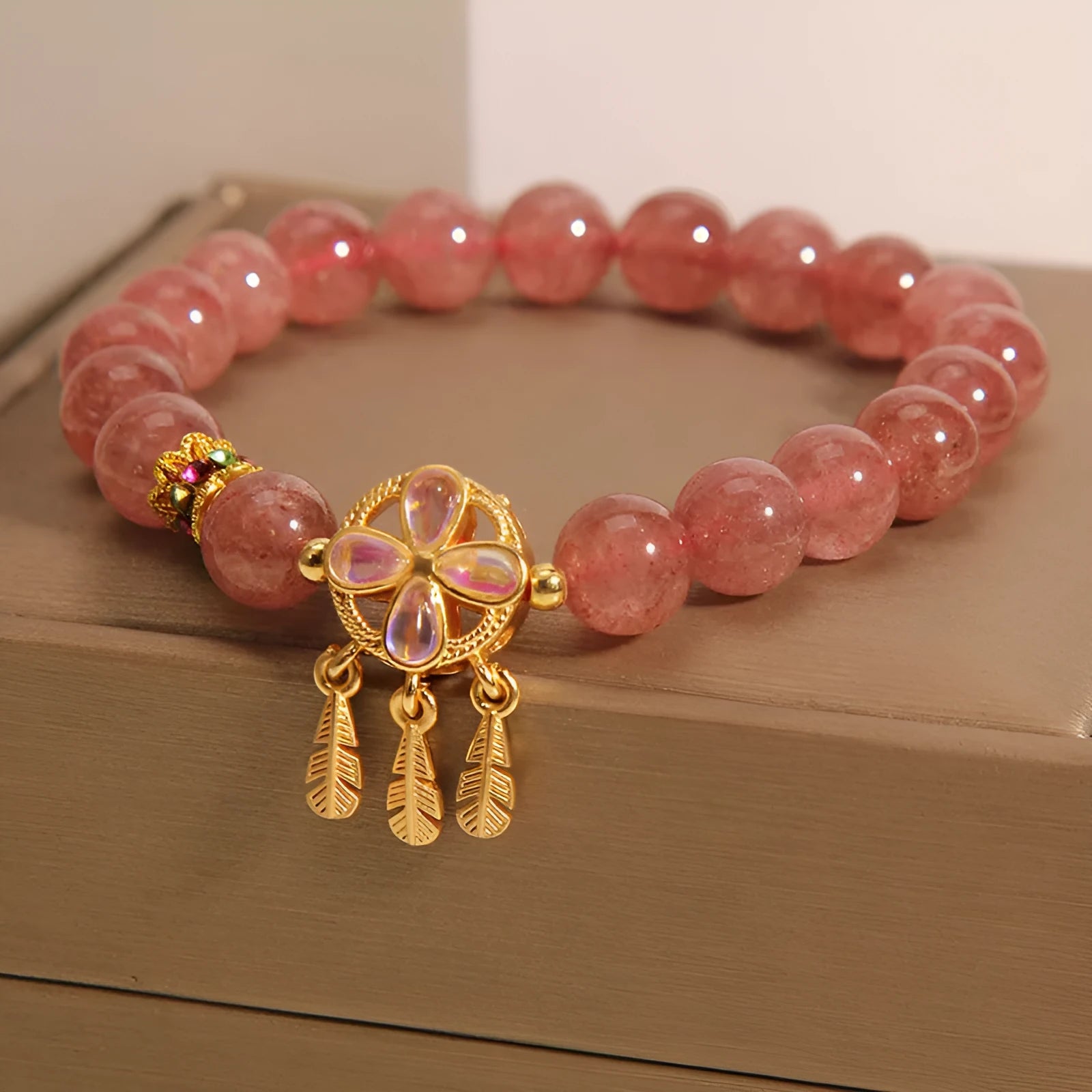 Women's strawberry quartz bracelet with four-leaf dream catcher pendant in natural crystal tones