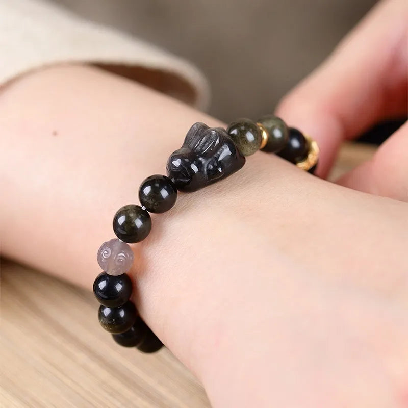 Handmade lying rabbit obsidian bracelet in brass with grey agate, showing national style design.