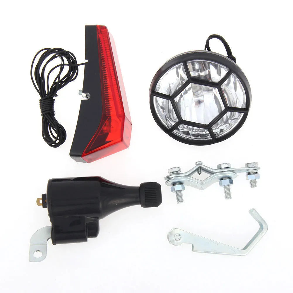 Silver aluminium bicycle dynamo light kit with generator, headlight, and tail light for friction-powered illumination.