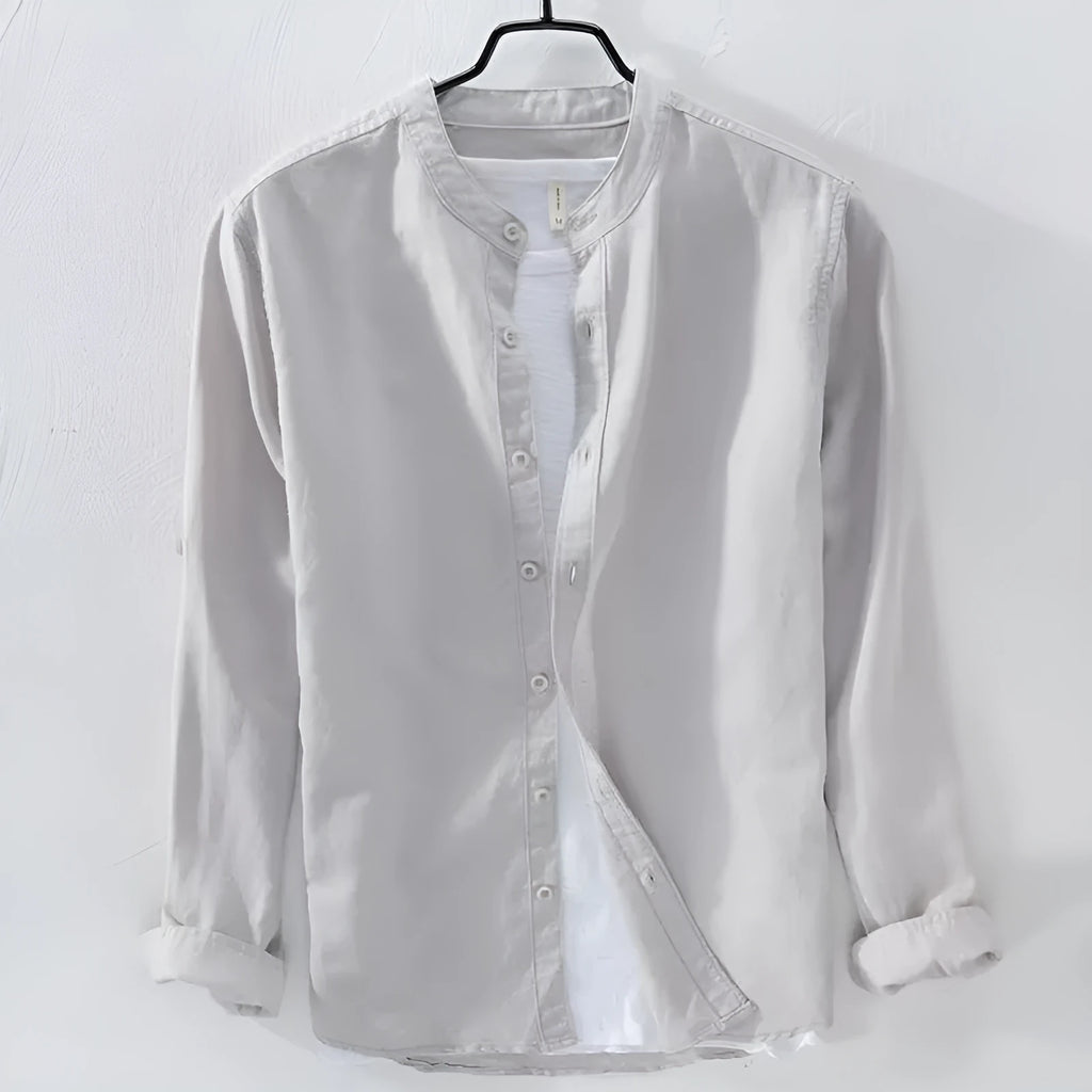 Man's loose fit long sleeve linen shirt in dark blue, showing button front and casual style.