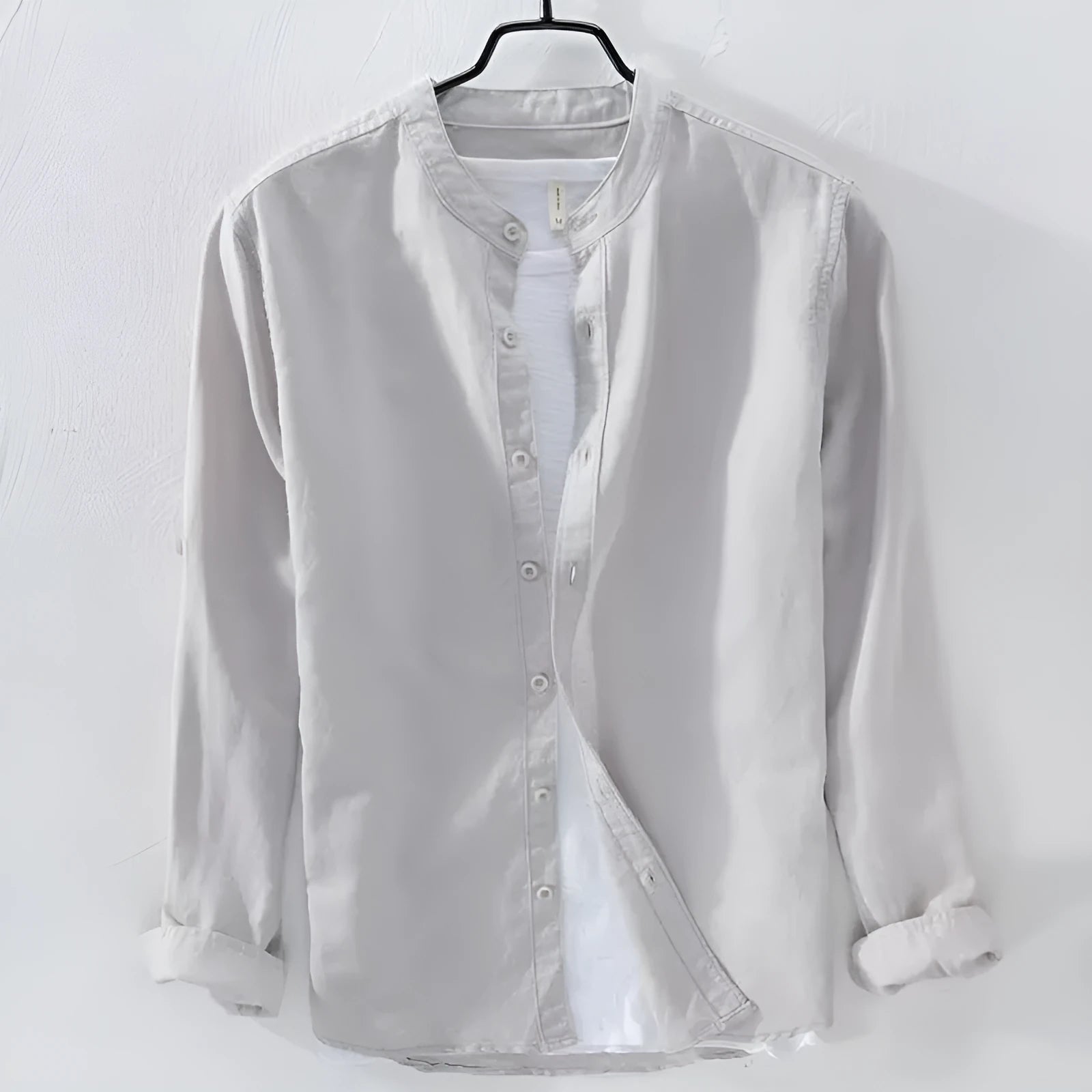 Man's loose fit long sleeve linen shirt in dark blue, showing button front and casual style.