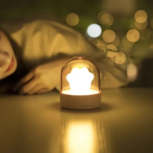 Grey or pink cat paw shaped USB rechargeable night light with musical functions on wooden desktop