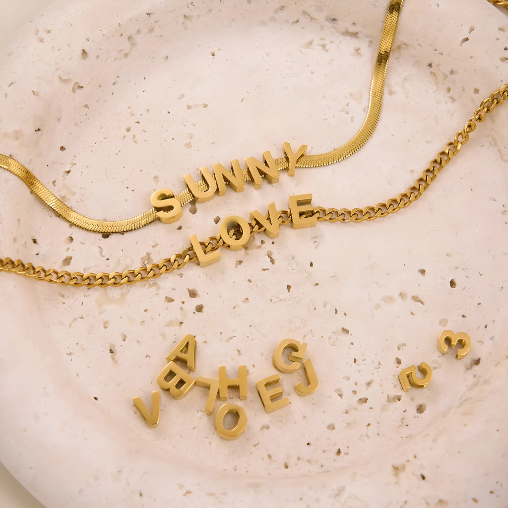 Titanium steel necklace with a single charm showing a number or letter on a 40.5cm gold or silver chain.