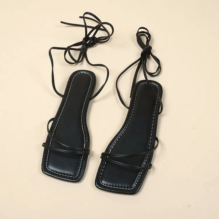Women's flat sandals with ankle ring bandage cloth detail in white, black and orange.