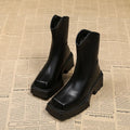 Black platform Martin boots for women with square toe, high heel, and back zip on a white background.
