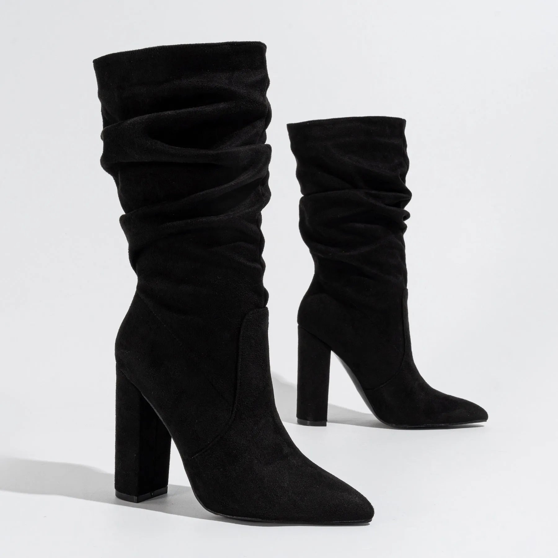 Women's black suede pointed-toe high heel boots with a chunky heel and middle calf length.