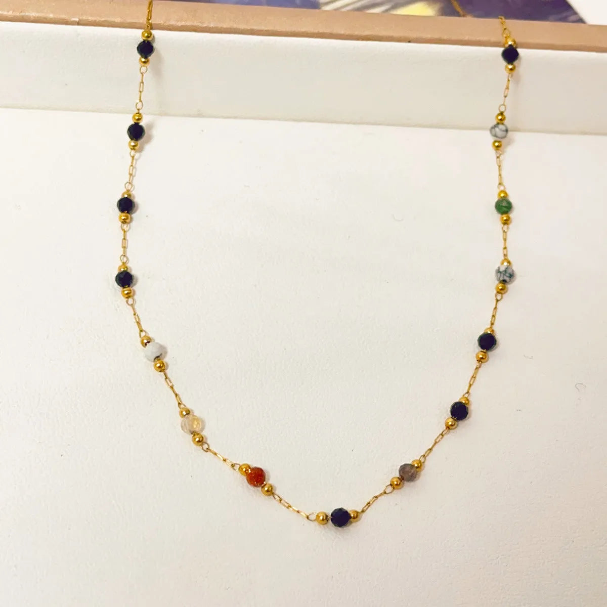 Gold titanium steel necklace with natural stone pendant showing O-ring chain and retro simple design