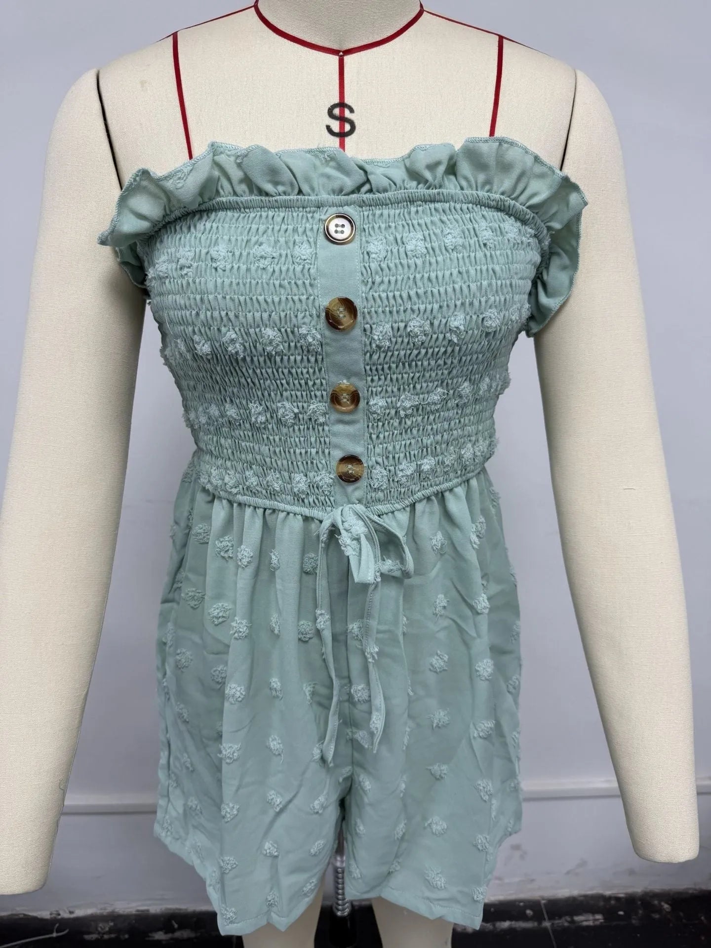 Blue women's off-shoulder sleeveless jumpsuit with button detail on mannequin