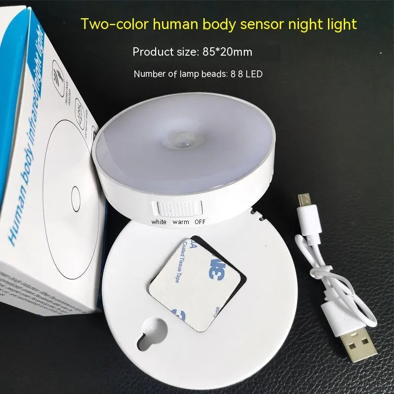 Compact round motion sensor LED night light with USB charging cable and adhesive mounting tape