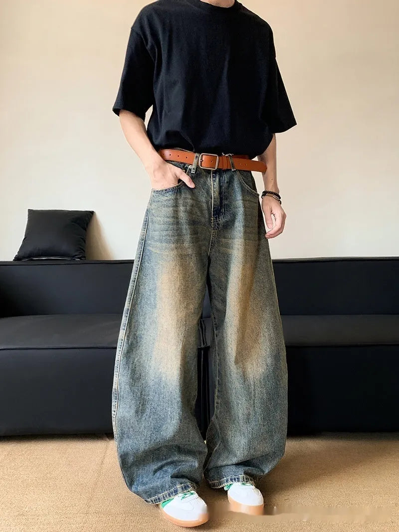 Man wearing retro blue distressed wide-leg denim jeans with a mid waist and zipper fly.