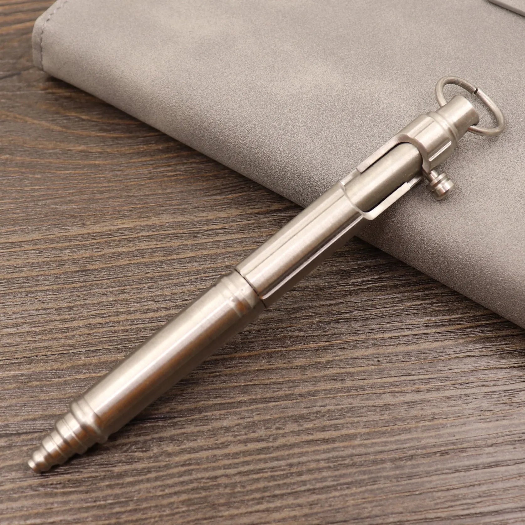 Brass bolt-action tactical pen in a retro copper finish, showing press mechanism and textured barrel.