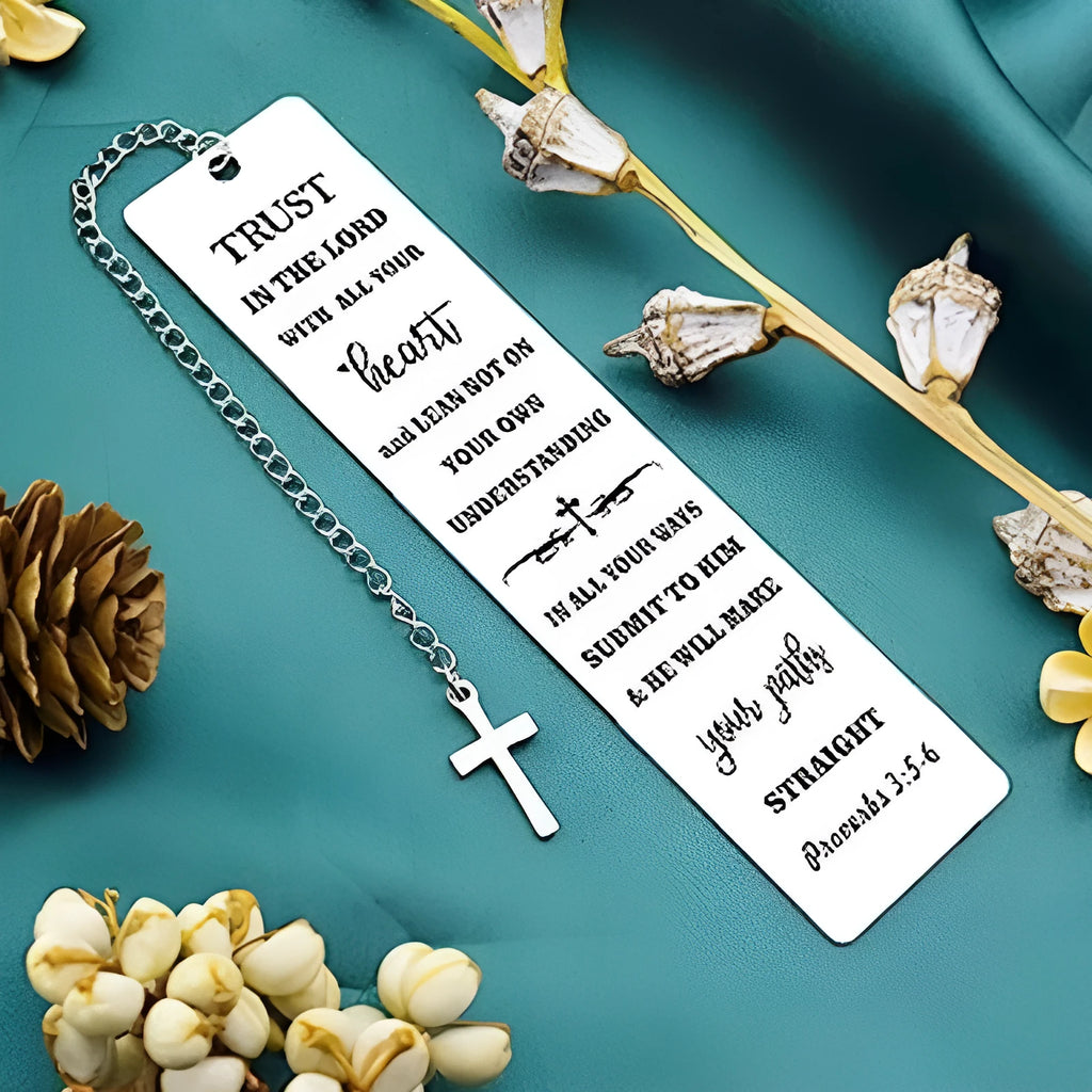 A polished stainless steel bookmark with an engraved inspirational verse, shown against an open book.