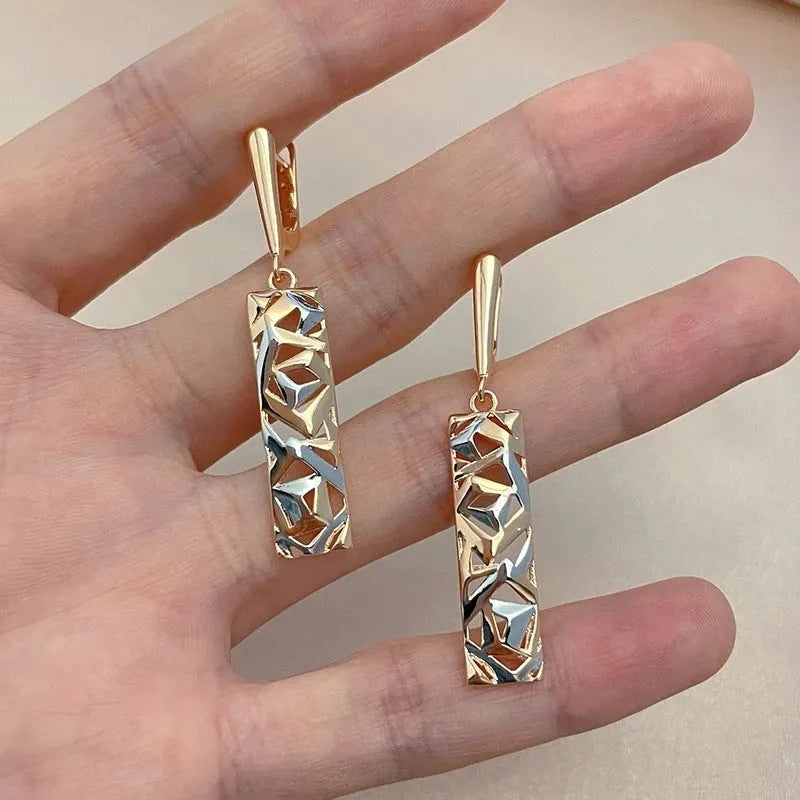 A pair of women's rectangular two-tone hollow stud earrings with a geometric design.