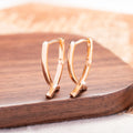 A pair of rose gold cross shaped fashion earrings on a copper alloy base.