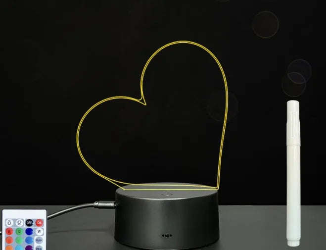 Black 3D acrylic message board LED light with remote control and marker pen on a desk.