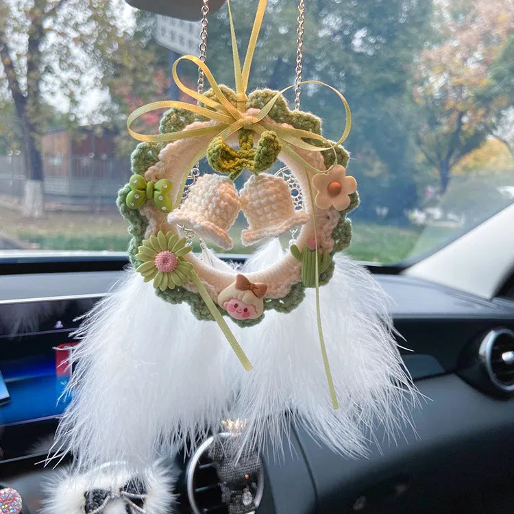 Handwoven wool bell orchid car pendant in green, hanging with dreamcatcher charm.