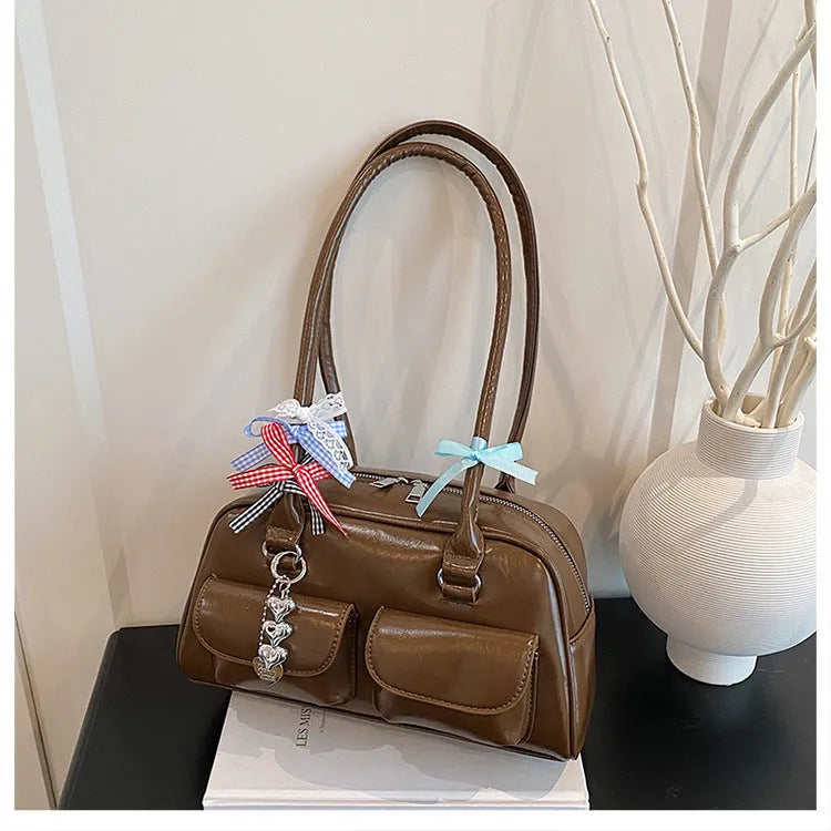 Brown PU leather retro pillow bag for women with a flap closure and double shoulder strap.