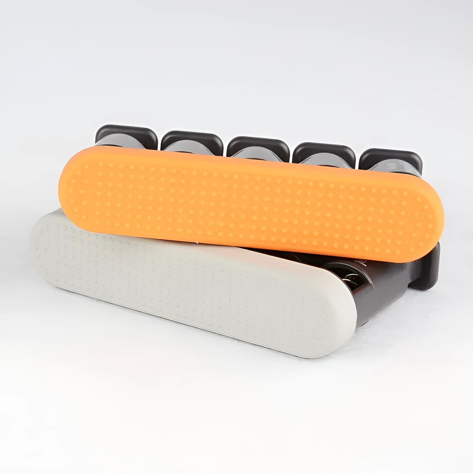 Grey non-slip silicone finger trainer for piano and guitar practice on a table.