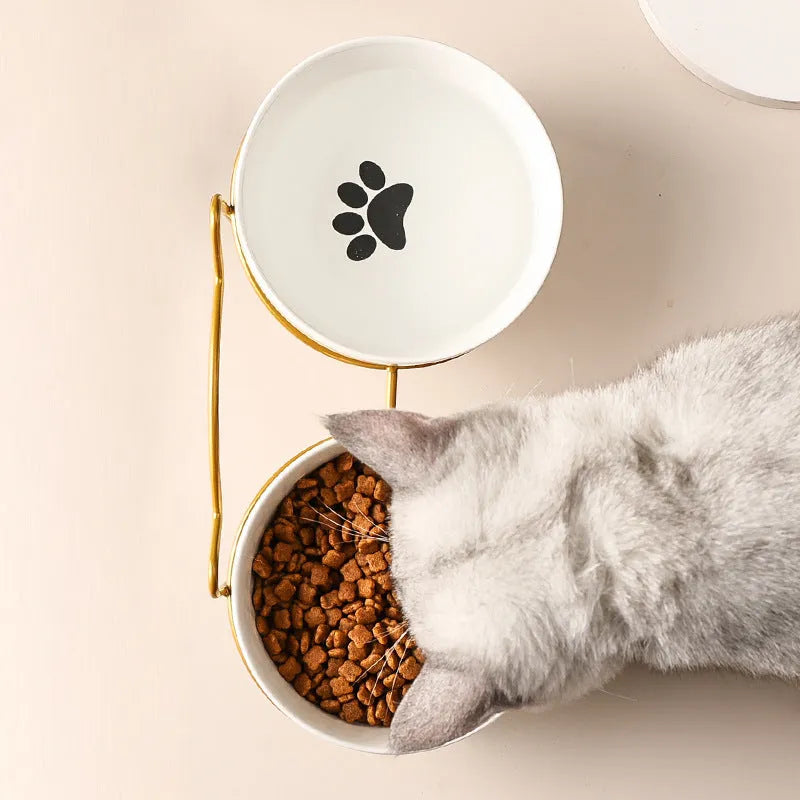 Ceramic cat bowl with iron frame stand showing cat paw print pattern and gold metal finish