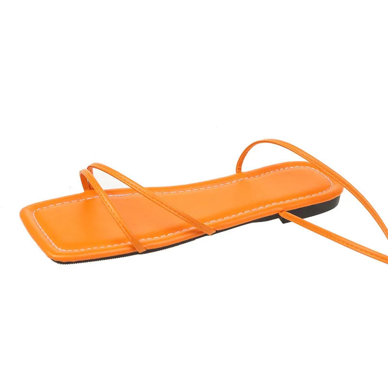 Women's flat sandals with ankle ring bandage cloth detail in white, black and orange.