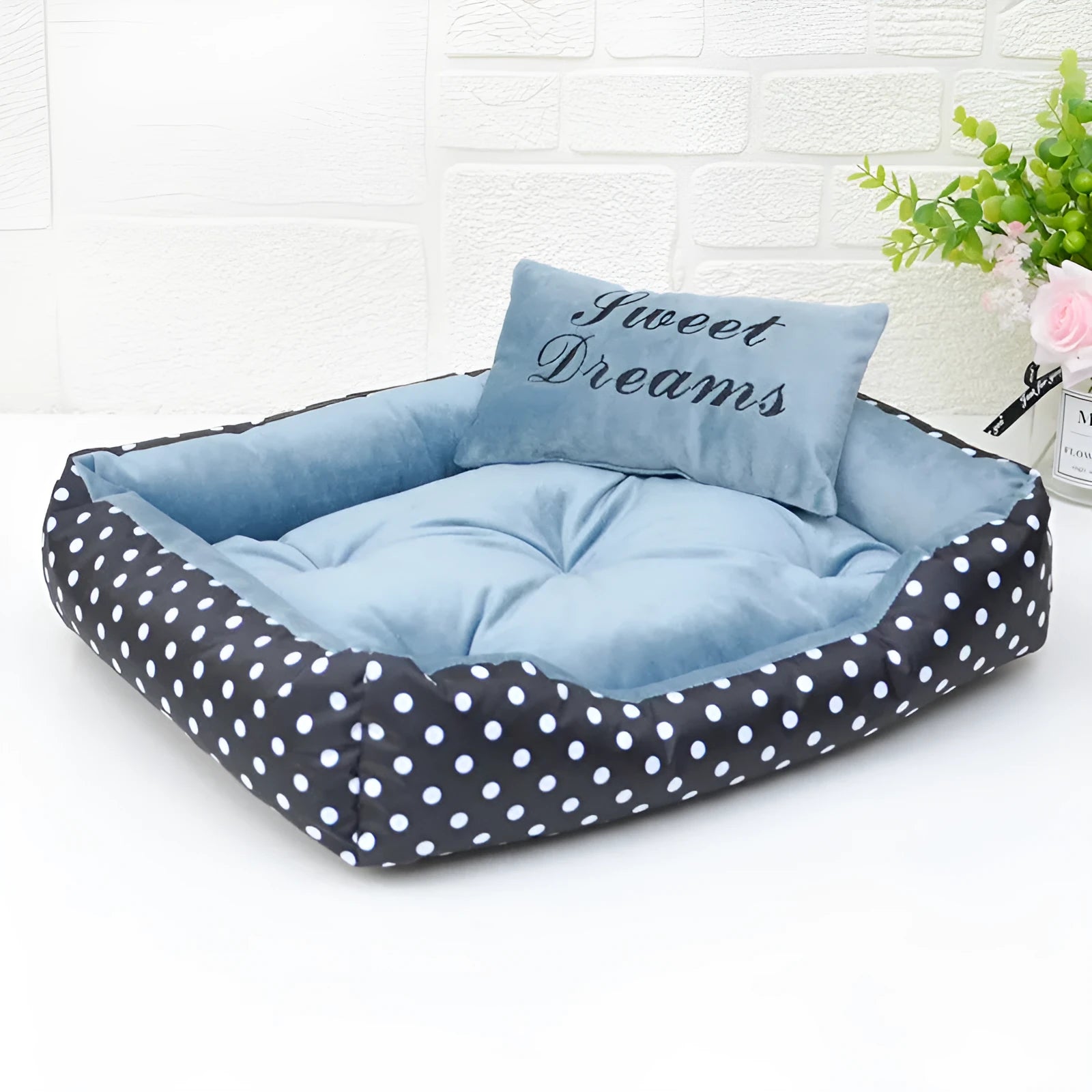 Polka dot printed square dog bed with raised bolsters and a matching embroidered pillow.