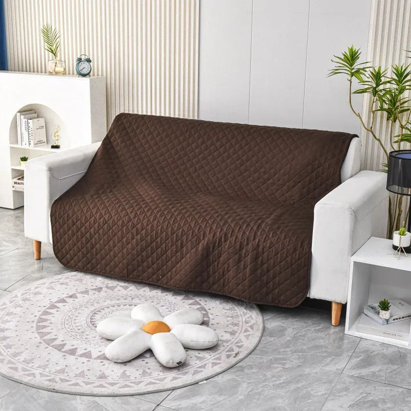 Reversible dog blanket showing two colours, laid flat on a sofa as a protective cover