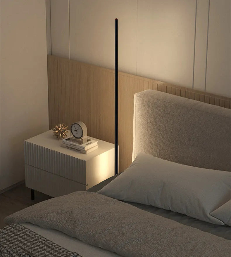 Simple modern vertical aluminium alloy floor lamp in silver, shown beside a sofa.