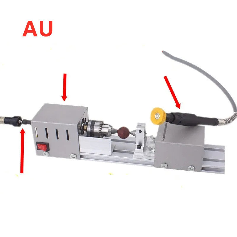 Silver metal mini manual woodworking lathe with carving knives on a workbench.