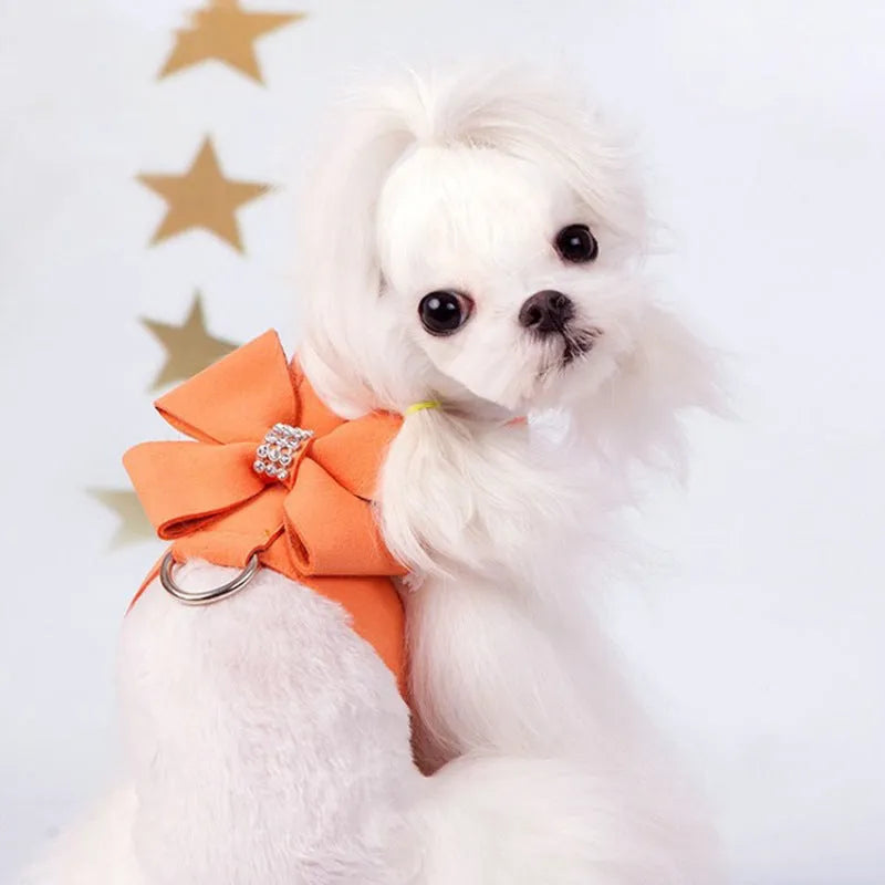 Soft pink microfiber puppy chest strap with a large white bowknot decoration laid flat.