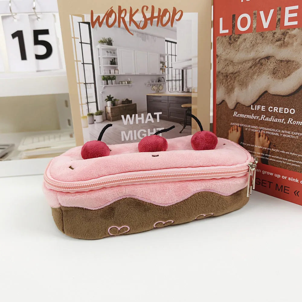Red velvet pencil bag with cherry cake pattern print, open to show empty interior.