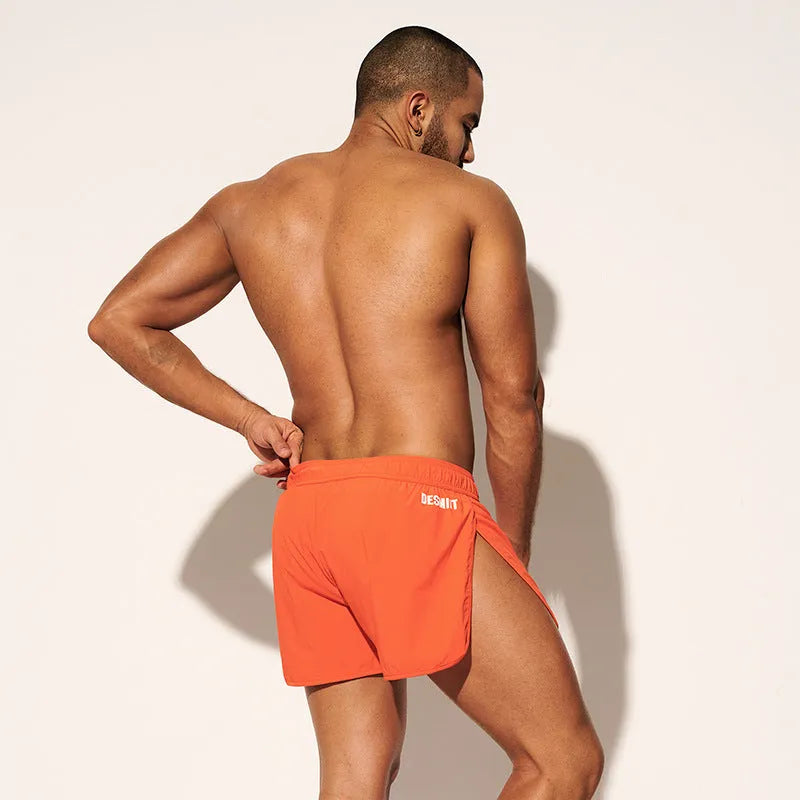 Men's loose beach shorts in orange, fluorescent green, and black colours with elastic waist