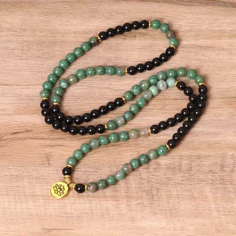 Green and black elastic beaded bracelet with alloy metal construction and natural style design