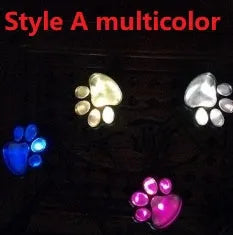 Set of four black bear paw print solar LED garden lights with a central solar panel pole on grass.