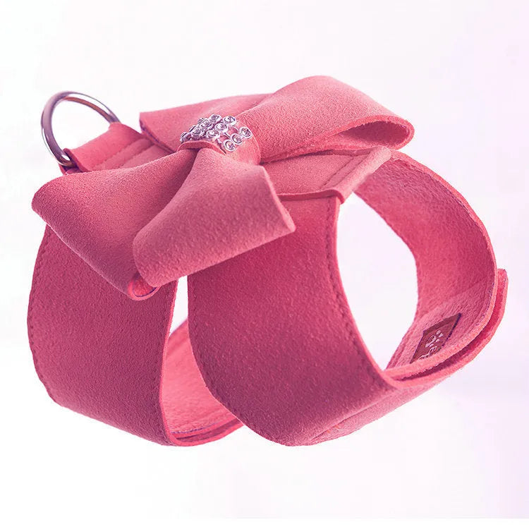 Soft pink microfiber puppy chest strap with a large white bowknot decoration laid flat.