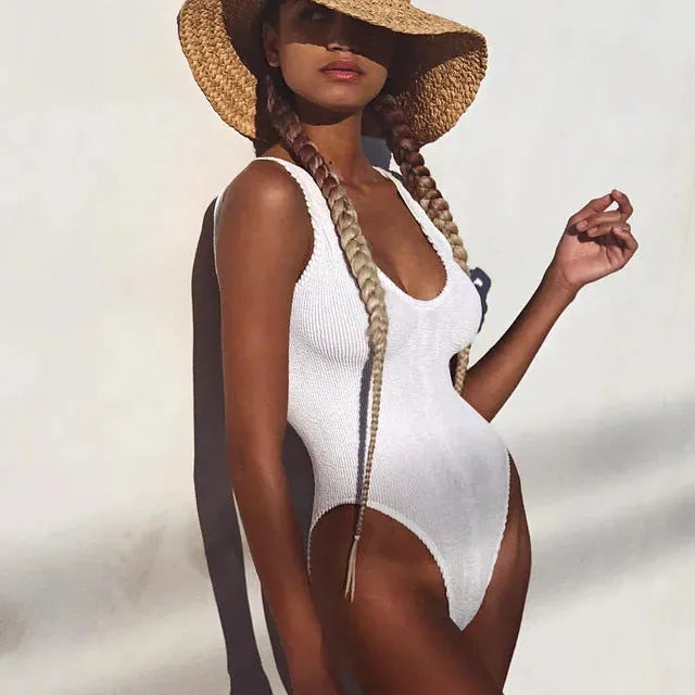 Women's solid colour one-piece swimsuit in seersucker bubble cloth fabric, showing backless design.