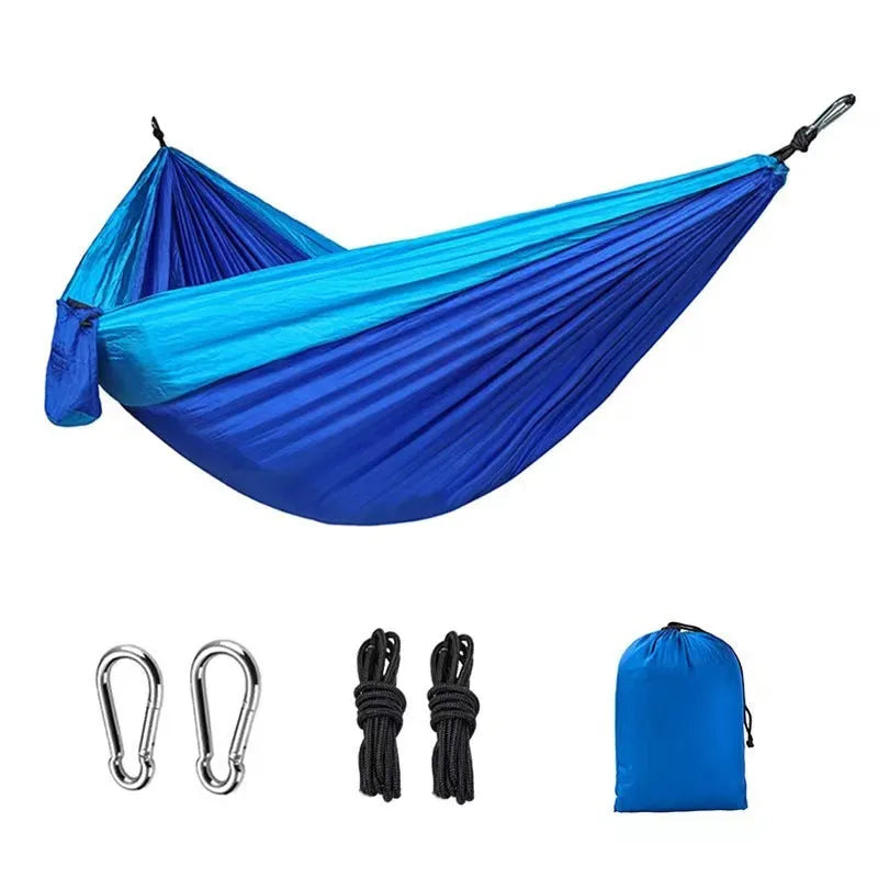 Blue nylon parachute cloth outdoor camping hammock shown in a natural setting.
