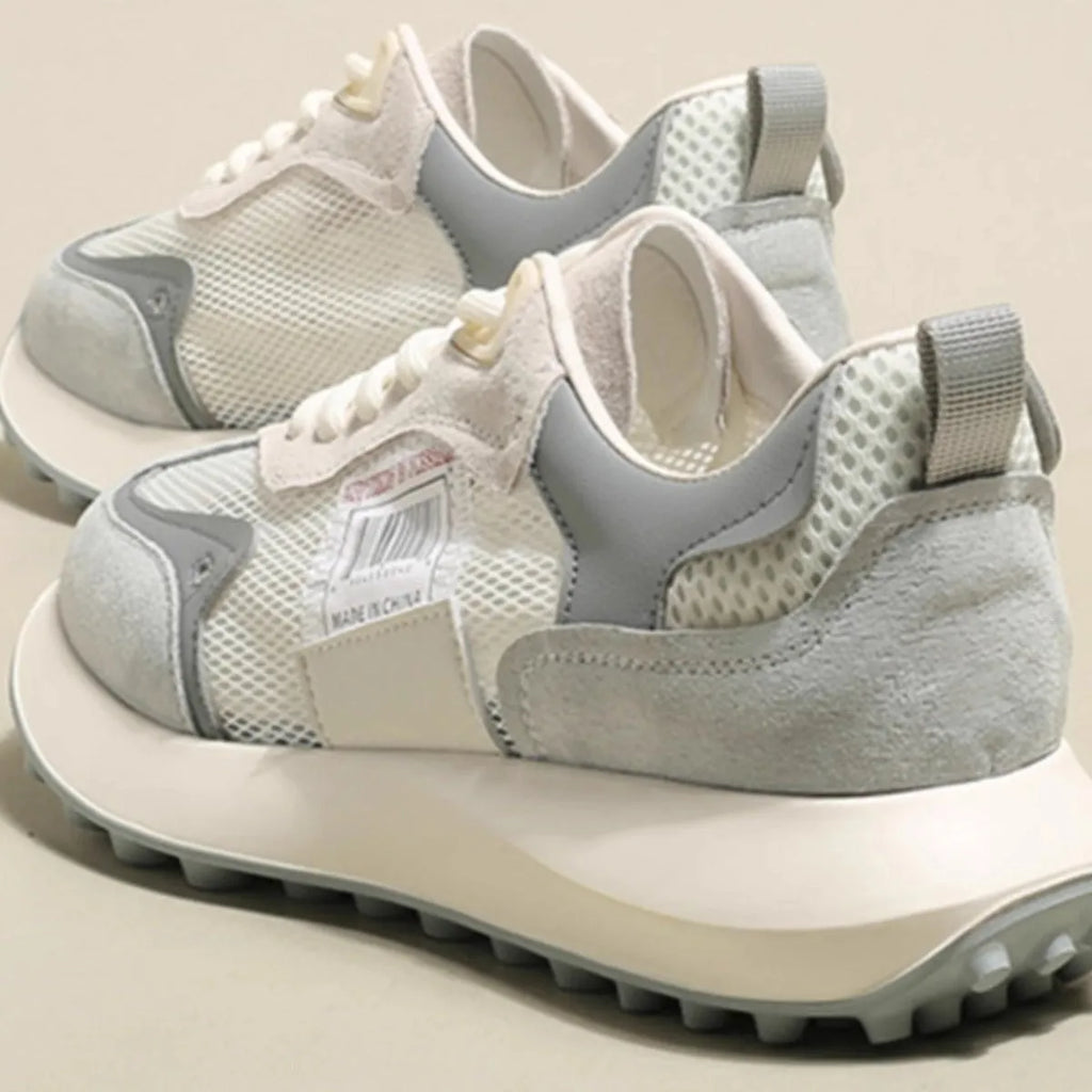 Grey and pink women's low-top retro sneakers with round toe and shallow mouth on a rubber sole.
